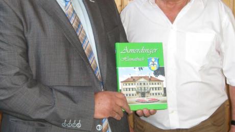 Sieben Jahre Forschungsarbeit stecken in dem Amerdinger Heimatbuch, das Autor Günter Besel (rechts) und Bürgermeister Hermann Schmidt in der Turn- und Festhalle Amerdingen im Rahmen eines Heimatabends präsentierten. 
