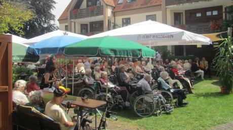Bewohner und Gäste bei der Eröffnung des Sommerfestes im Seniorenheim.