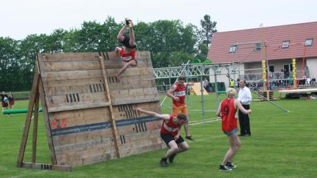 Die Mitspieler überqueren im dritten Spiel eine drei Meter hohe Holzmauer. Das klappt nur mit gegenseitiger Hilfe. 
