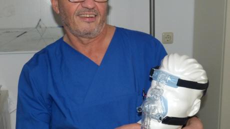 Dr. Helmut Kern, Chefarzt des Schlaflabors an der Donau-Ries-Klinik Oettingen, demonstriert eine Schlafmaske gegen das Schnarchen.  	