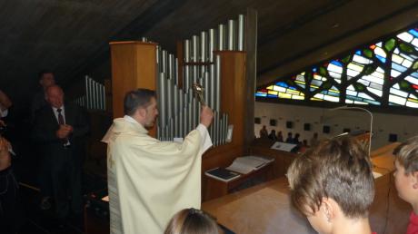 Pfarrer Benjamin Beck segnet die neue Kisselbach-Orgel in der Fessenheimer Christkönigskirche.  	