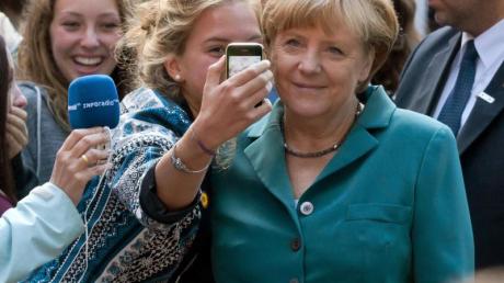 Angela Merkel lässt sich in Berlin mit einer Schülerin fotografieren.