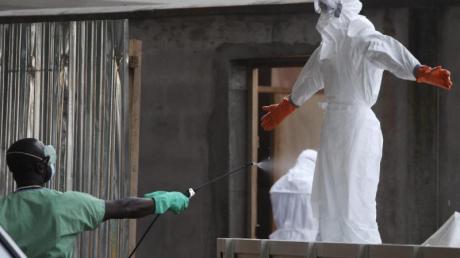 In einem Krankenhaus im liberianischen Monrovia wird eine Schwester desinfiziert. Das Ebola-Virus breitet sich immer weiter aus.
