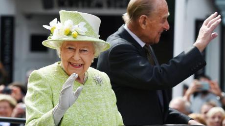 Königin Elizabeth II. und Prinz Philip grüßen aus einer offenen Kutsche auf der Fahrt durch Windsor.