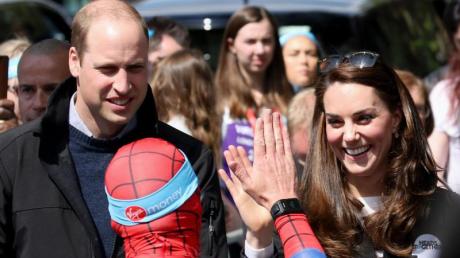Prinz William und seine Frau, Herzogin Kate, feuern einen Läufer im Spider-Man-Kostüm an.