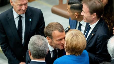 Angela Merkel wird am Rande des UN-Klimagipfels von Emmanuel Macron und Harrison Ford (links) begrüßt.