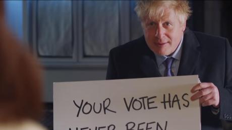 Boris Johnson, Premierminister von Großbritannien, hält in einem Wahlwerbespot der Konservativen ein Schild mit der Aufschrift „Your vote has never been more important“.