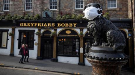 Die Welt ist eine andere: Die Statue von Greyfriars Bobby im schottischen Edinburgh trägt eine Atemschutzmaske. 	