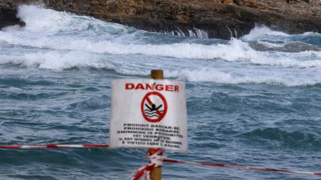 Ein Schild verbietet das Schwimmen am Strand von Cala Mendia in Manacor auf Mallorca. Zwei junge Urlauberinnen sind hier ertrunken.  	