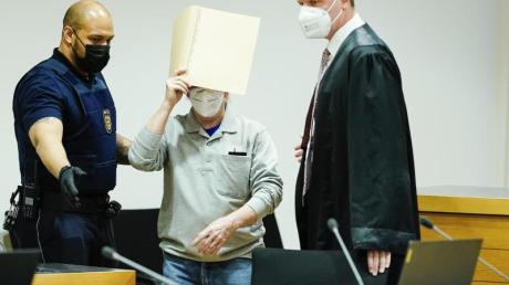 Der Angeklagte (M) mit seinem Anwalt Steffen Lindberg (r) und einem Justizbeamten zu Prozessbeginn im September im Gericht.