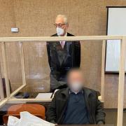 Der angeklagte Vater (vorne) zusammen mit seinem Anwalt (hinten) vor dem Prozess am Landgericht München I.