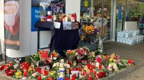 Blumen und Kerzen erinnern an einer Tankstelle in Idar-Oberstein an den jungen Kassierer, der am 18. September 2021 von einem mit einer Pistole bewaffneten Mann erschossen wurde.
