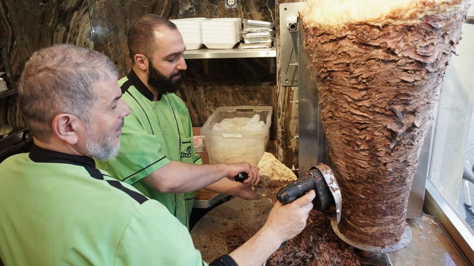 Halit (left) and Halip from Berlin's Imren Grill prepare a doner kebab.  It is said that it was invented fifty years ago.