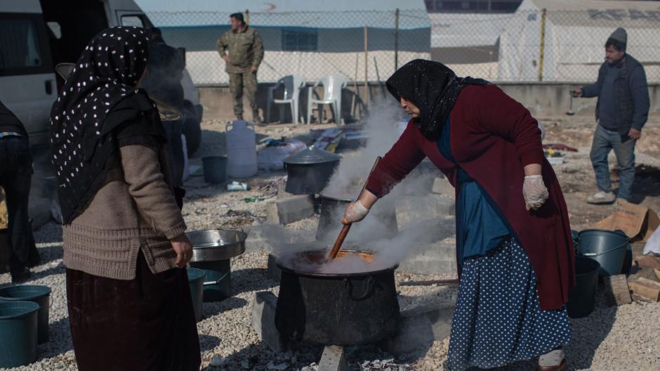 Türkische Frauen bereiten in einem Behelfslager in Kahramanmaras draußen Essen zu.
