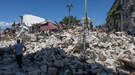 Ein Mann geht in der Altstadt von Antakya an den Trümmern eingestürzter Wohnhäuser durch das Erdbeben vorbei.