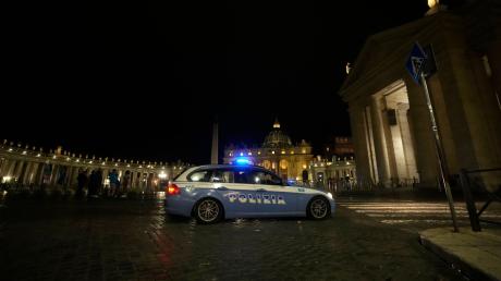 Ein italienisches Polizeiauto fährt am späten Abend vor dem Petersplatz im Vatikan vorbei.