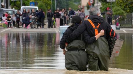 Menschen bringen sich auf einer überfluteten Straße im norditalienischen Lugo in Sicherheit.