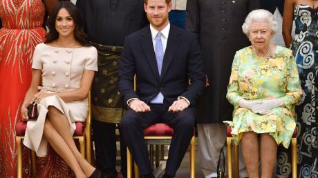 Die britische Königin Elizabeth II., Prinz Harry und seine Frau Meghan auf einer Aufnahme aus dem Sommer 2018.