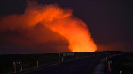 Blick auf die Gaswolke, die von der Lava des ausbrechenden Vulkans beleuchtet wird.