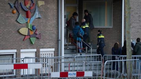Zwei niederländische Polizeibeamte betreten das Hochsicherheitsgebäude des Gerichts.