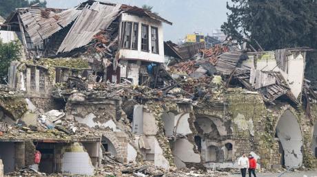 Zwei Männer gehen an einer völlig zerstörten Häuserzeile in Antakya vorbei. Im Zentrum der Stadt waren bei dem Beben vor einem Jahr unzählige Häuser zerstört oder beschädigt worden.