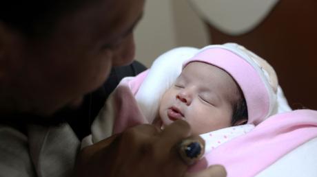 Adoptivvater Chalil Sawadi betrachtet Afraa wenige Tage nach ihrer Geburt. Das kleine Mädchen wurde unter Trümmern des Erdbebens in Syrien am 6. Februar 2023 geboren.