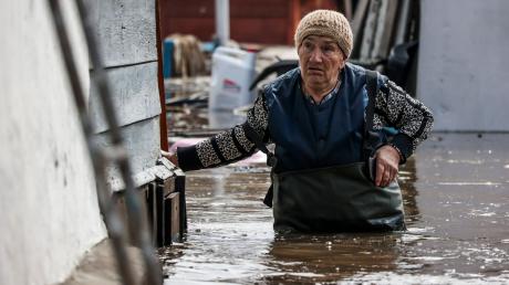 Eine Frau in der Nähe ihres Hauses in einem überschwemmten Gebiet in Orenburg, Russland.