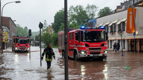Feuerwehrleute bewegen sich durch das Hochwasser in Saarbrücken.