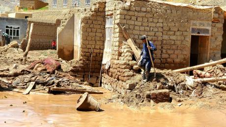 Ein Mann sammelt nach schweren Überschwemmungen in der Provinz Ghor seine Habseligkeiten zusammen.