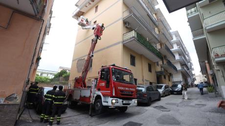 Von einem Hubwagen aus inspiziert ein Feuerwehrmann Schäden an einem Gebäude in Pozzuoli.