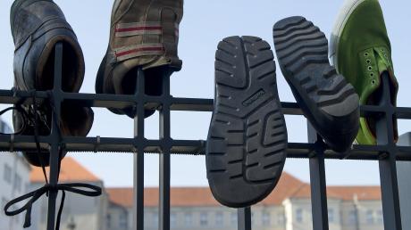 Schuhe hängen in Berlin bei einer Demonstration für den Rücktritt von Verteidigungsminister Karl-Theodor zu Guttenberg (CSU) vor dem Verteidigungsministerium an einem Zaun. Im Internet wurde unter dem Motto "Guttenberg zurücktreten" zu der Demonstration aufgerufen. Die Schuhe sind eine Anspielung auf Guttenbergs vergessene Fußnoten. Außerdem ist es im Islam ein Symbol der Schmähung.