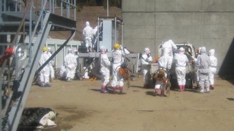 Arbeiter von Tepco in Strahlenschutzanzügen, wie sie vergangene Woche versuchen, einen der Reaktoren an eine Notstromleitung anzuschließen.  