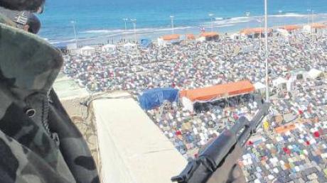 Ein Soldat der Aufständischen bewacht im libyschen Bengasi die Gläubigen bei ihrem Freitagsgebet am Strand.  