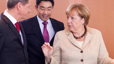 Bundeskanzlerin Angela Merkel (CDU) spricht mit Wirtschaftsminister Philipp Rösler und Außenminister Guido Westerwelle (beide FDP, l). dpa