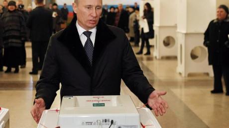 Wladimir Putin wählt. Foto: Yuri Kochetkov dpa