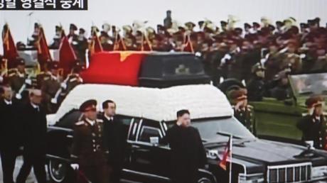 Das TV-Bild des nordkoreanischen Staatsfernsehens zeigt den Sarg von Kim Jong Il in Pjöngjang. Vorne neben dem rechten Kotflügel salutiert sein Sohn und Nachfolger Kim Jong Un. Foto: Yonhap News Agency/epa dpa