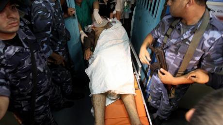 Nach den Gefechten begleiten bewaffnete Palästinenser einen Verletzten ins Krankenhaus.