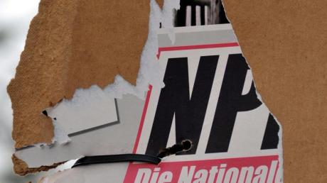 Ein zerrissenes Wahlplakat der NPD an einem Laternenmast.