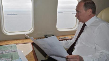 Wladimir Putin beobachtet vom Helikopter aus ein Marinemanöver.