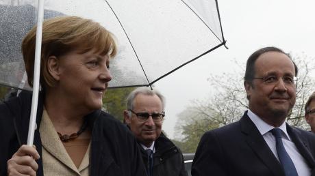 Kanzlerin Angela Merkel, Frankreichs Staatschef François Hollande: Trotz Regens kommen Bilder der Einigkeit den beiden europäischen Führungspolitikern angesichts der etwas aus dem Lot geratenen deutsch-französischen Achse gerade recht.  
