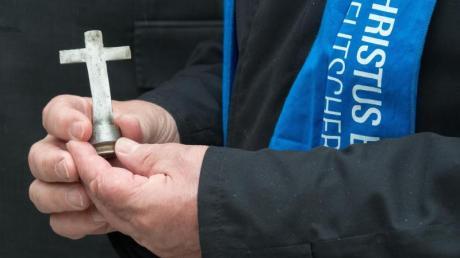 Ein kleines Kreuz, das im Kongo aus Patronenhülsen hergestellt wurde, in den Händen von Bundespräsident Gauck während einer Veranstaltung beim Katholikentag in Regensburg.
