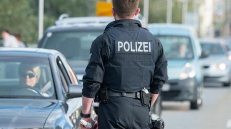 Ein Bundespolizist kontrolliert Fahrzeuge an der deutsch-österreichischen Grenze in Simbach am Inn.  Ist das alles noch zu schaffen? (Symbolbild)