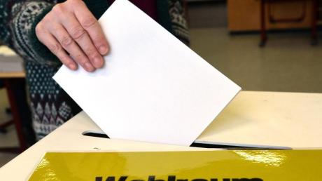 Eine Frau steckt in einem Wahllokal in Ludwigsburg in Baden-Württemberg ihren Stimmzettel in die Wahlurne.