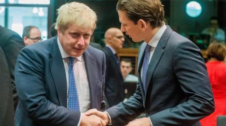 Boris Johnson (l) und Österreichs Außenminister Sebastian Kurz begrüßen sich in Brüssel.