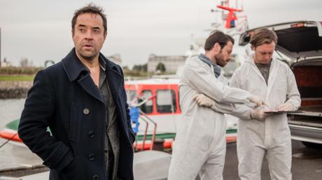 Vom Gerichtsmediziner im ARD-„Tatort“ zum Kommissar im ZDF: Jan Josef Liefers (links) nimmt als Ermittler Jan Holzer im Hafen von Wilhelmshaven die Arbeit auf.  	