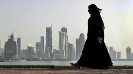 Eine Frau vor der Skyline der Stadt Doha in Katar.