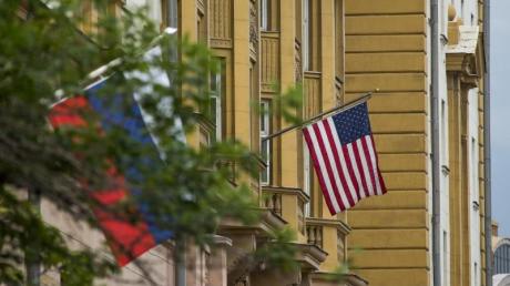 Die Nationalflaggen von Russland (l) und den USA vor der US-Botschaft in Moskau (Russland). Nach dem Beschluss neuer Sanktionen gegen Moskau durch den US-Kongress müssen die USA ihr diplomatisches Personal in Russland reduzieren.