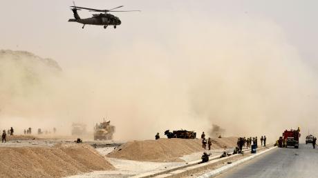 Nach dem Anschlag auf einen Nato-Konvoi sondiert ein Hubschrauber die Lage von der Luft aus, während Soldaten das Gebiet mit ihrer Waffe im Anschlag sichern. Ein Augenzeuge berichtete von mindestens drei Todesopfern. 	 	