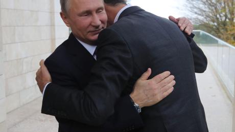 Putin (links) und Assad umarmen sich bei ihrem Treffen in Sotschi.  	 	