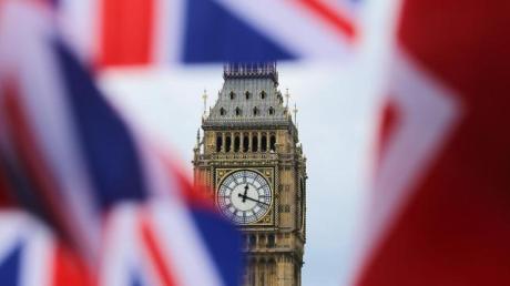 Britische Fahnen vor dem berühmten Uhrturm Big Ben in London. Bald scheidet Großbritannien aus der EU aus (Symbolbild).